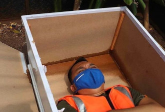 印尼为呼吁戴口罩，违反者躺棺材五分钟