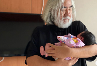 张纪中怀抱刚出生的小女儿，头发花白眼神宠溺