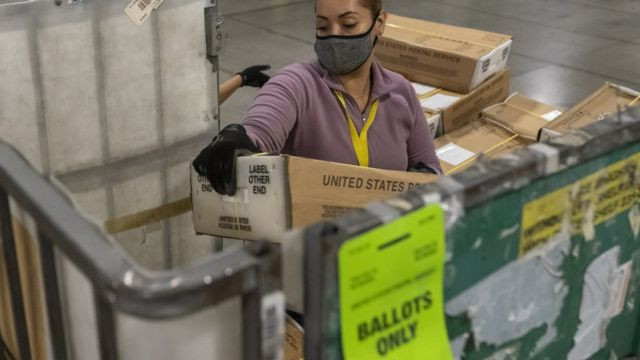 在俄勒冈州,一名邮政工作人员卸下数以千计装满选票的盒�。