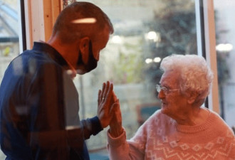 男子和92岁母亲久别相会，隔着玻璃握手