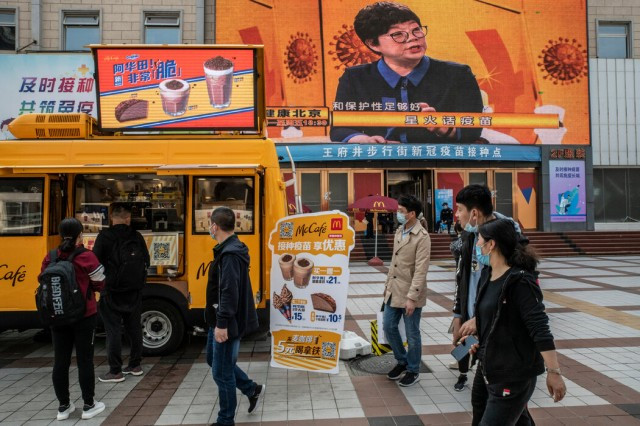 在北京一家新冠疫苗接种�心外，麦当劳的冰淇淋车为接种者推出“买一赠一”的促销活动。
