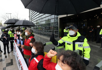 韩国民众冒雨在日大使馆前抗议 警察打伞