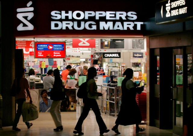 People walk past a Shoppers Drug Mart store in Toronto July 19, 2006. REUTERS/Peter Jones