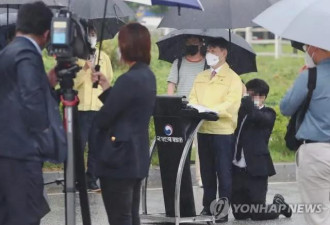 韩法务部官员雨中记者会 有人双膝下跪给他撑伞