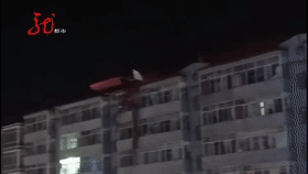 哈尔滨一楼房房盖被大风吹跑 整条马路中断