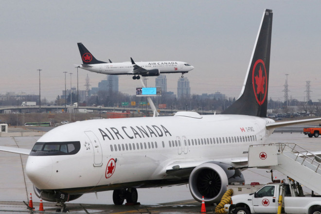 An Air Canada Boeing 737 MAX 8 from San Francisco approaches for landing at Toronto Pearson International Airport over a parked Air Canada Boeing 737 MAX 8 aircraft in Toronto
