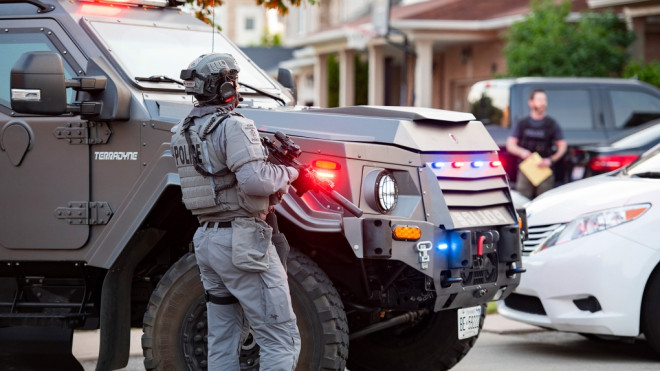 Police and an armoured vehicle are seen outside a home in an undated YRP image.