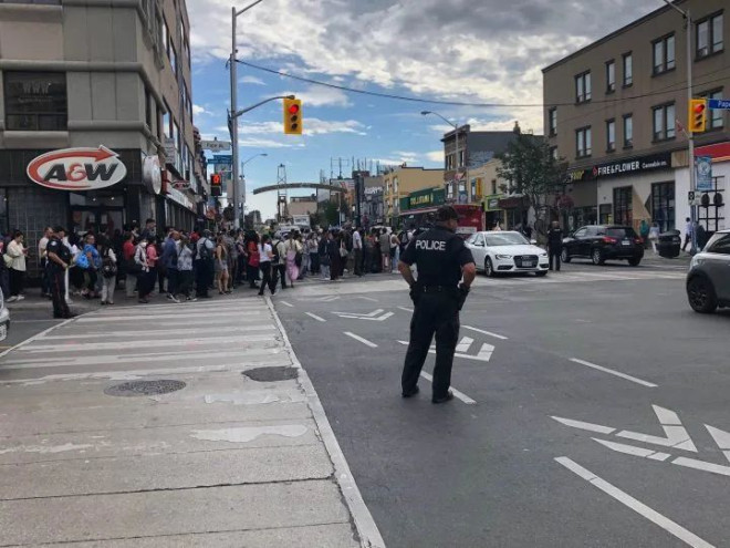 A large crowd is seen in Toronto Tuesday morning after the TTC suspended service on part of Line 2 due to a fire.
