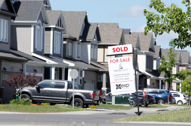 A realtor's for sale sign stands outside a house that had been sold in Ottawa