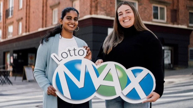 Two people holding a Lotto Max sign.