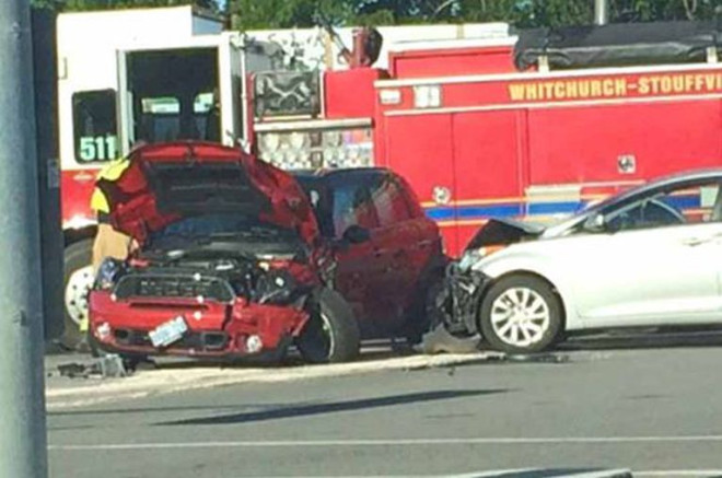 A wrecked red car and a white car with a damaged hood