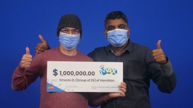 Two members of a group of 26 people collect their $1million winnings from the OLG. (Provided)