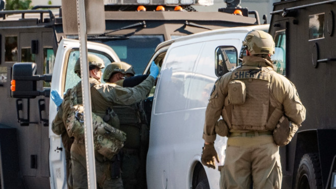 SWAT team members enter a van and look through its contents in Torrance Calif., Jan. 22, 2023. (AP Photo/Damian Dovarganes)