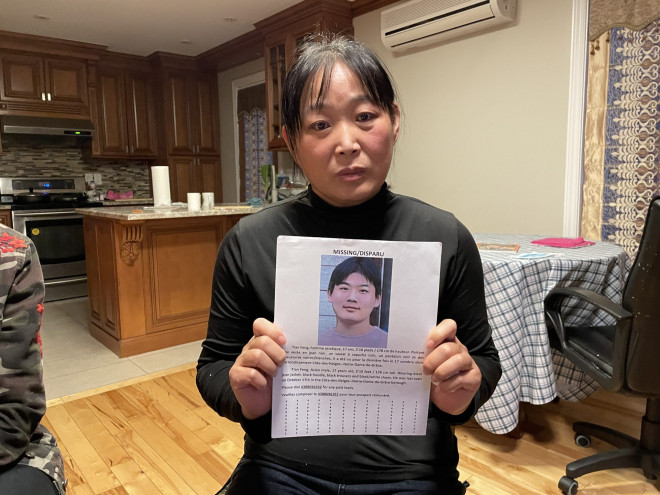 Feng Tian's mother Sujing Nie holds a missing flyer of her son who has been missing since Oct.17