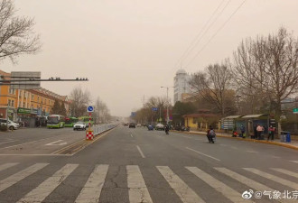 北京天气实况：天空昏黄，空气中弥漫着泥沙味