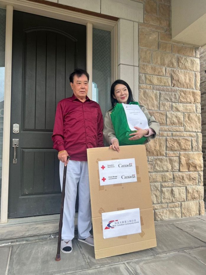 Two people standing next to a sign Description automatically generated with low confidence