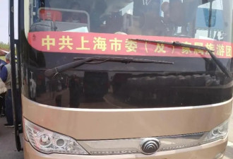 大巴挂“上海市委及家属旅游团”条幅