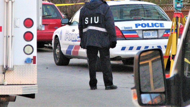 A Special Investigations Unit investigator works at the scene of a shooting in Toronto on Feb. 20, 2012. (Canadian Press)