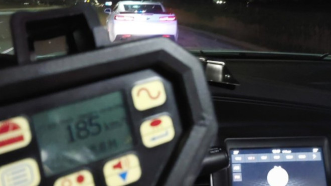 An OPP officer stops a vehicle on Highway 400 in King Township, Ont., on Tues., May 16, 2023, for speeding 185km/h. (OPP/Twitter)