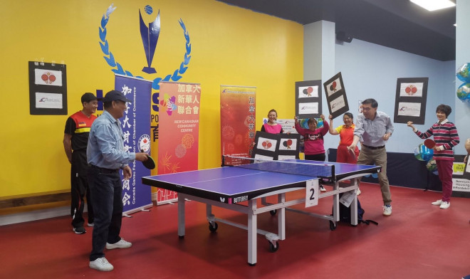 A group of people playing ping pong  Description automatically generated