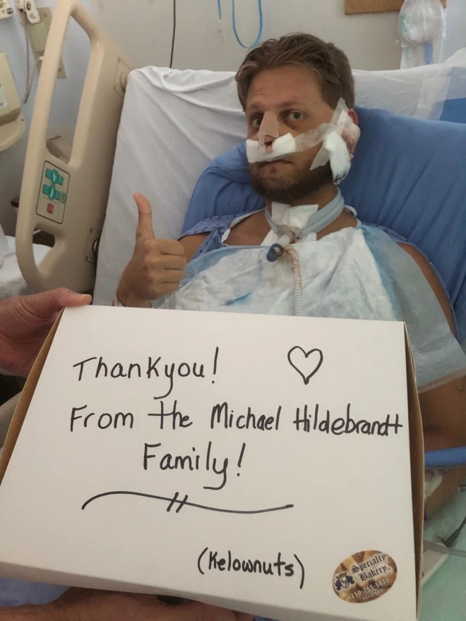 Micheal Hildebrandt displays a thank you sign in his hospital room for all the care he has received.