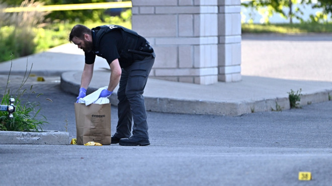 An Ottawa Police officer collects evidence after a Saturday night shooting at the Infinity Convention Centre that left two dead, in Ottawa, on Sunday, Sept. 3, 2023. (Justin Tang/THE CANADIAN PRESS) 