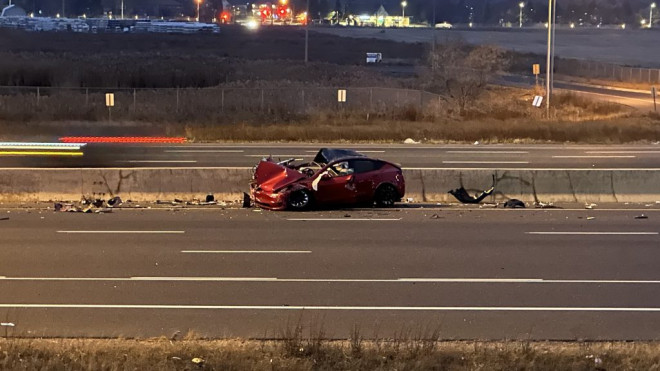 A badly damaged Tesla is seen in the passing lane of Highway 400 following an early morning crash