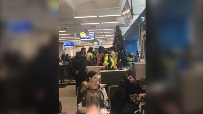Passengers seen speaking with customer service representatives at the Region of Waterloo International Airport after their Flair Airlines flight to Mexico was cancelled on Dec.24. (Submitted: Marie Anthony)
