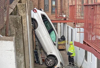 华裔女司机挂错档，倒车垂直坠入两墙间