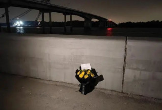 被撞断的大桥旁有人留下鲜花和字条：梁金华...