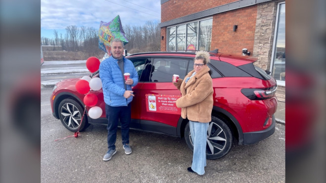 Joe Mazzotta along with his wife Christine get a sneak peek at the new electric Volkswagen SUV he won in Tim Hortons' 'Roll Up to Win' contest on March 21, 2024. (Sean Irvine/CTV News London) 