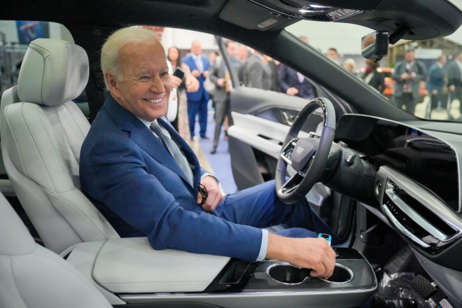 President Biden sits in an electric vehicle at the Detroit Auto Show.