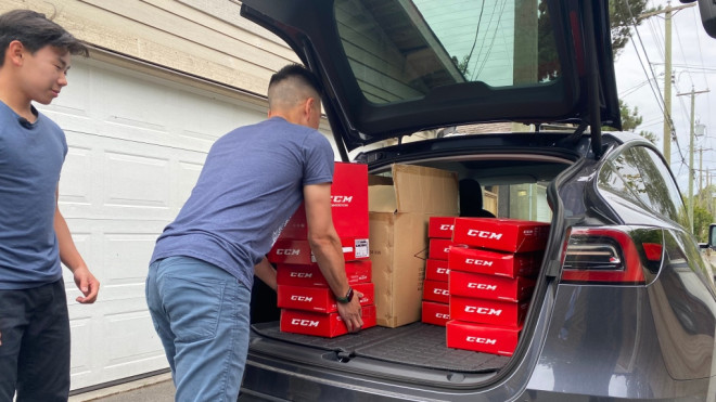 Cameron Lee, 16, and his dad load up a car with hockey gear that will be donated to teams in the Yukon. 