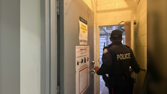 An officer guards a garbage area on the main floor of a midtown Toronto building where a baby was found on Nov. 20 with life-threatening injuries. The infant was later pronounced deceased. (Janice Golding/CTV News Toronto)