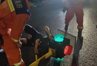 社死！男子骑电动车玩手机不看路 头部卡进红绿灯