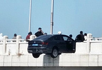 轿车撞断大桥护栏悬空中 过路男子冲上前压住车头