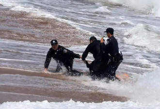 海南陵水一游客不慎被海浪卷走，3名警员合力救回