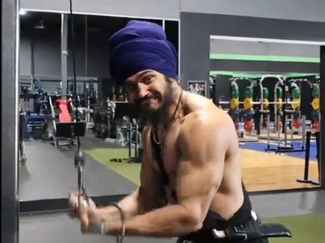 锡克教徒 Gurpartap Singh Khalsa 佩戴仪式短剑在健身房锻炼
